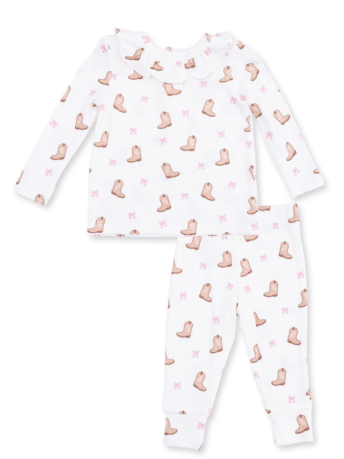 White long-sleeve pajama set with boot and pink bow prints for children. Cozy and stylish sleepwear option.