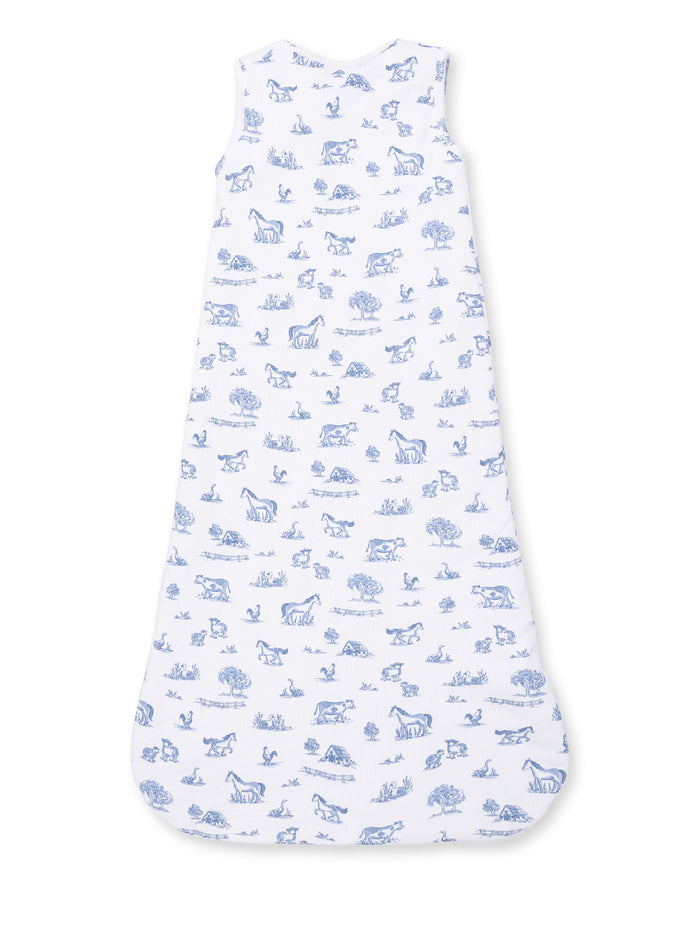 White sleep sack with blue farm animal and nature print, featuring horses, cows, trees, and birds.