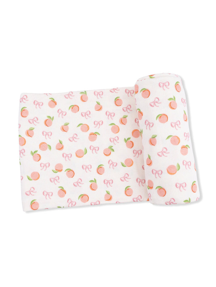 Patterned fabric featuring peaches and bows in soft pastel colors.