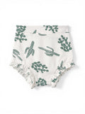 White fabric diaper cover with green cactus patterns and ruffled edges.