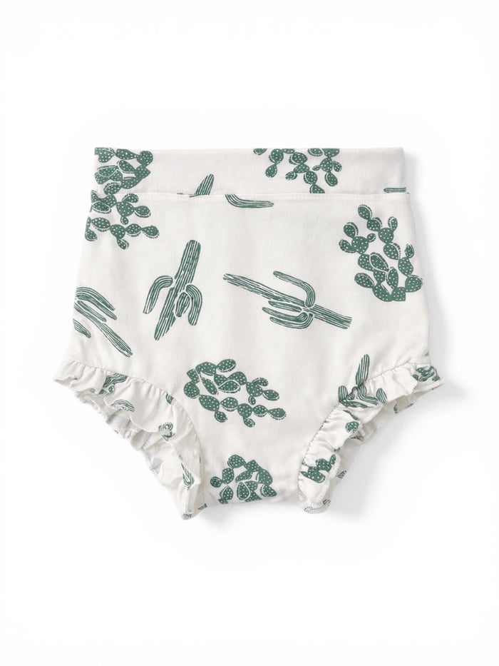 White fabric diaper cover with green cactus patterns and ruffled edges.