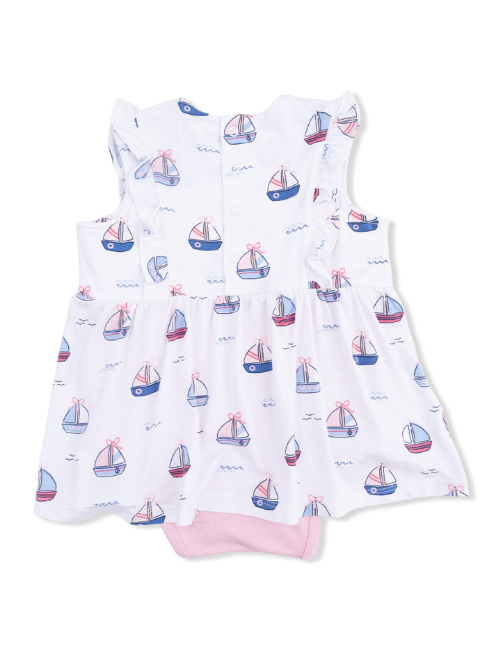 White baby dress with boat print, ruffled shoulders, and pink details, perfect for warm weather outfits.
