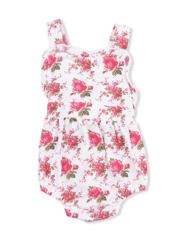 Floral baby romper in white with pink roses and green leaves, featuring wide straps and a gathered waistband.