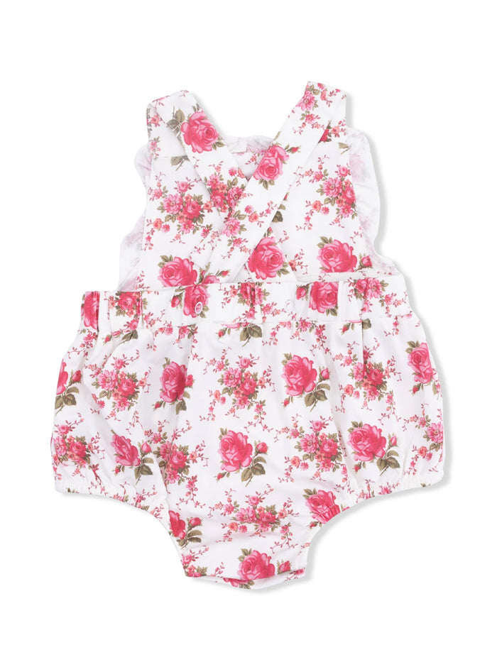 White floral romper with pink roses and green leaves, featuring cross-back straps and ruffled detailing.
