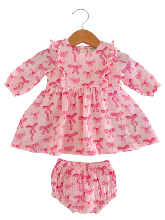Pink dress with bow patterns and matching bloomers, displayed on a hanger against a white background.