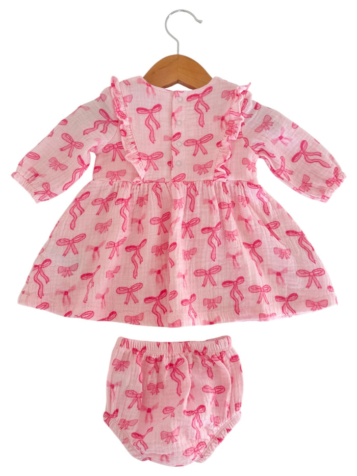 Pink floral dress with matching bloomers, featuring a ruffled collar and bow patterns.