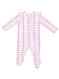 Light pink baby onesie with ruffled shoulders and a playful pattern of brown acorns and pink bows.