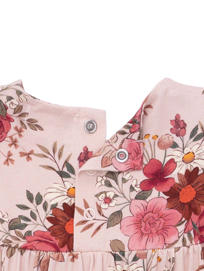 Floral-patterned fabric of a dress with snaps at the neckline in soft pastel colors.