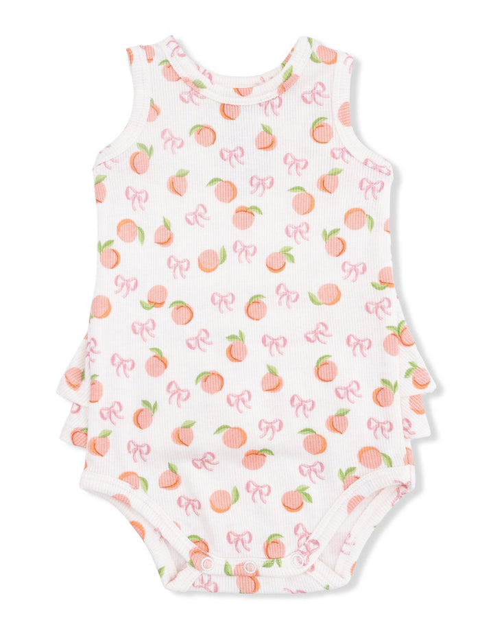 White sleeveless baby onesie with peach and bow patterns, featuring ruffle accents on the sides.