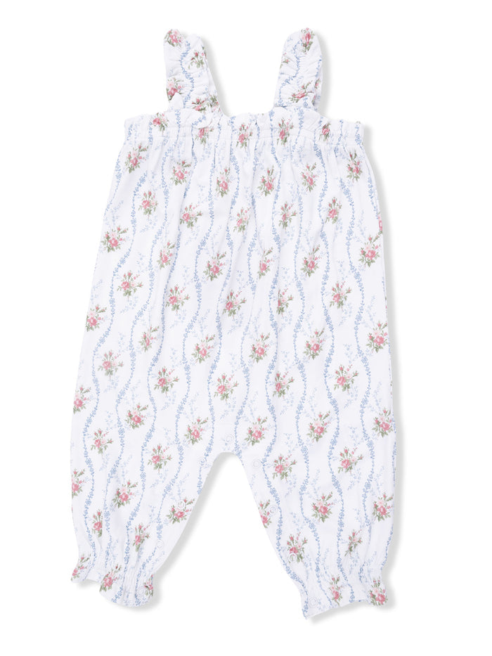 White floral romper with blue and pink flowers, featuring smocked bodice and ruffled straps. Perfect for warm weather.