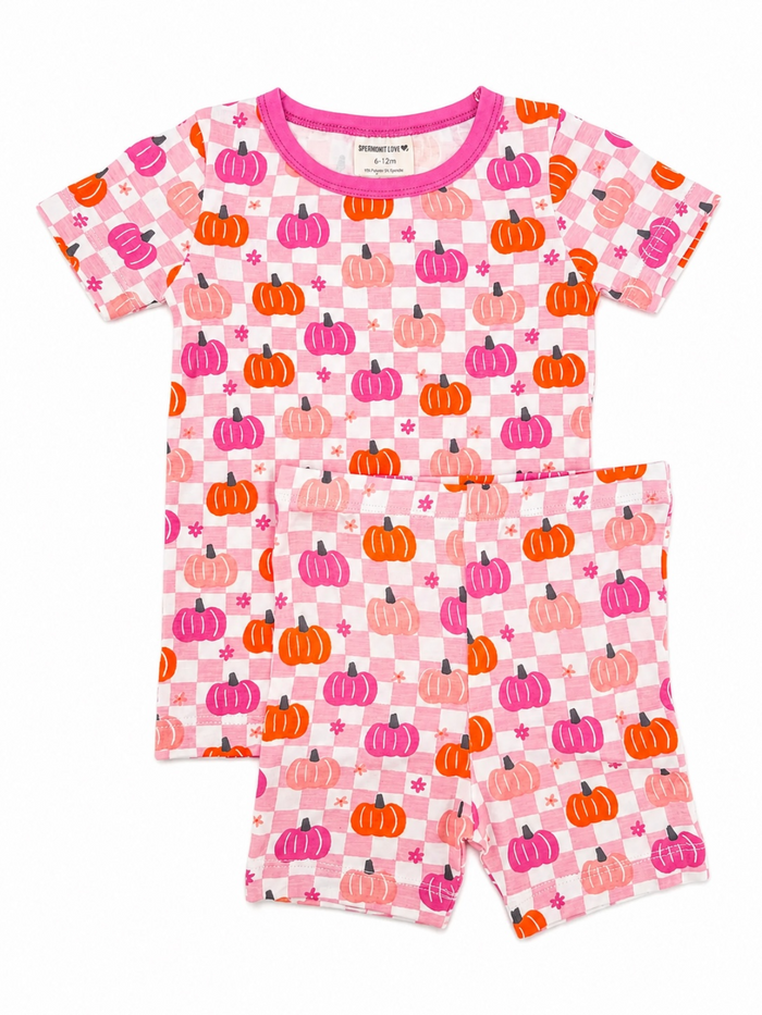 Pink pajamas with colorful pumpkin patterns, featuring a short-sleeve top and shorts. Perfect for cozy nights.