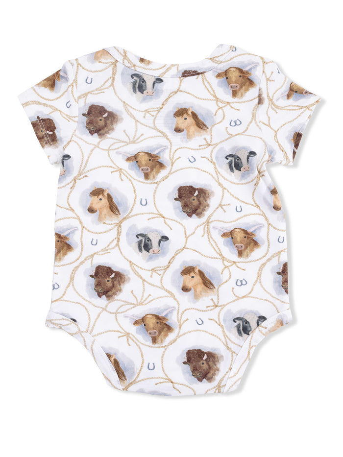 White baby onesie with watercolor animal faces, including horses, cows, and goats, in a playful pattern.
