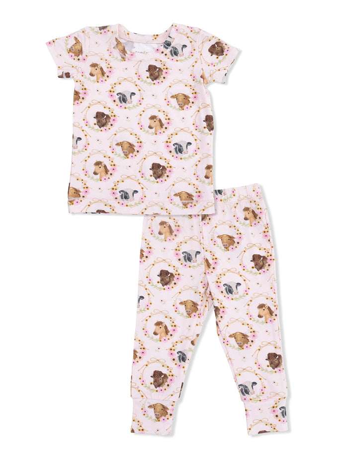 Pink pajama set featuring a whimsical dog print with floral accents, suitable for kids.