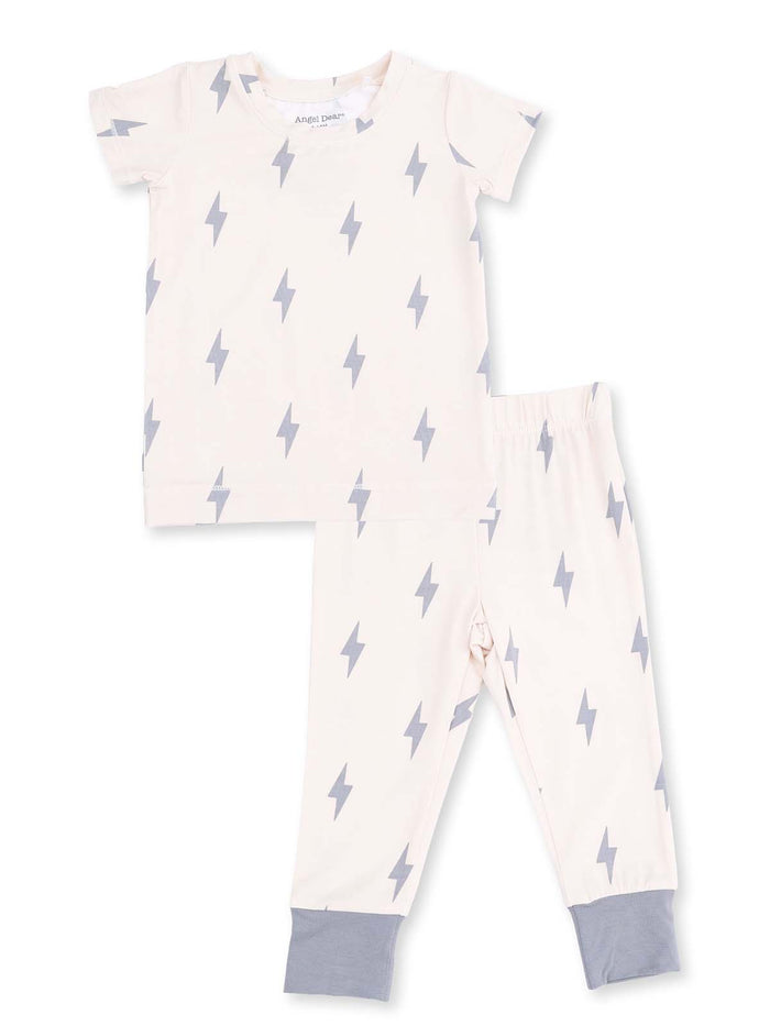 Light beige children’s pajama set with grey lightning bolt pattern on shirt and pants.