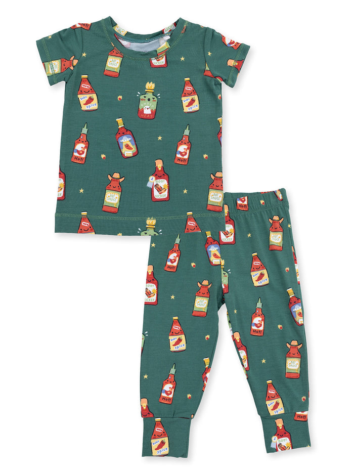 Kids' pajama set featuring a green background with colorful condiment bottle designs.