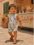 Child enjoying ice cream in a colorful outfit, walking past a gelato shop in a sunny, charming street.