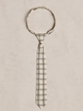 Gray and cream checkered tie laid flat on a light textured background.
