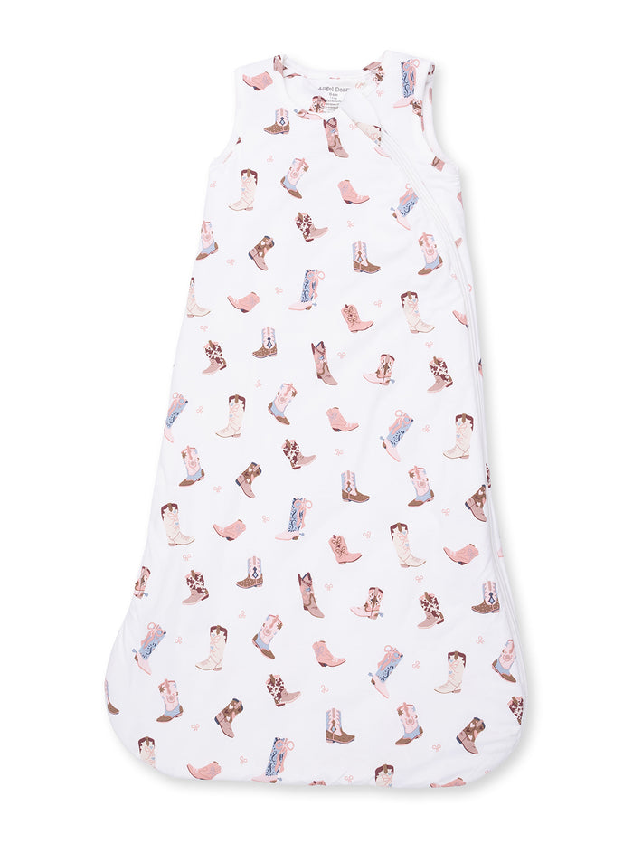 White baby sleeping sack with a playful cowboy boot pattern in soft pastel colors.