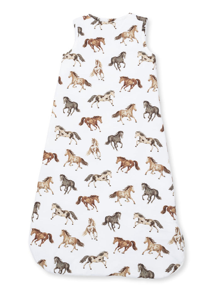 Child's sleep sack featuring a playful horse print in various colors on a white background.