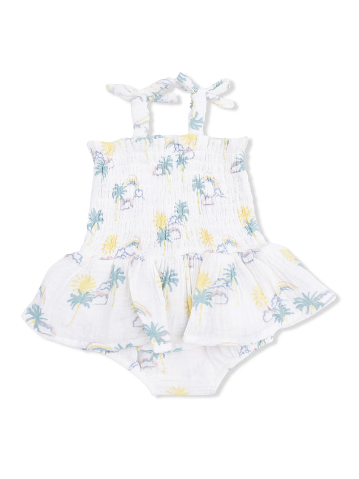 White patterned baby romper with palm trees and sun designs, featuring spaghetti straps and a flared skirt.