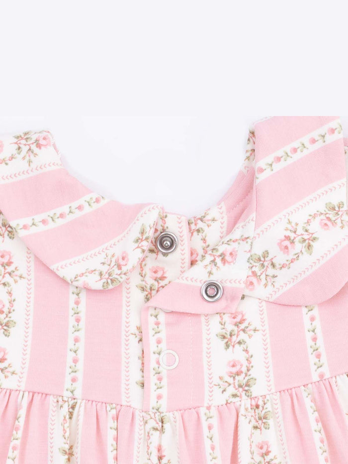 Pink floral dress featuring a collar, snap buttons, and vertical striped patterns. Ideal for young children.