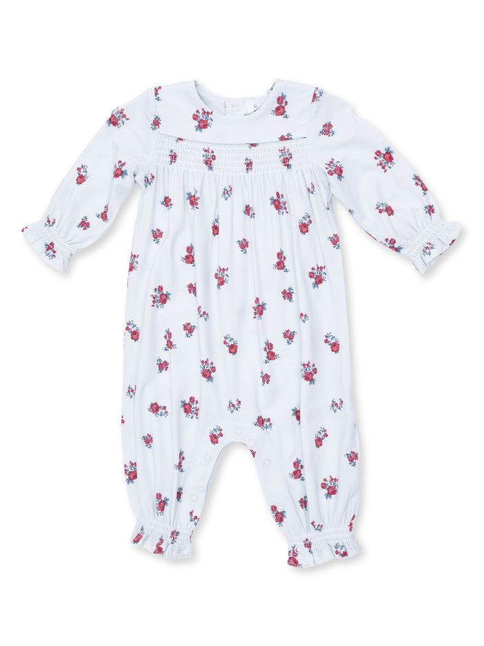 White floral baby romper with long sleeves and button closure, featuring small red rose patterns throughout.