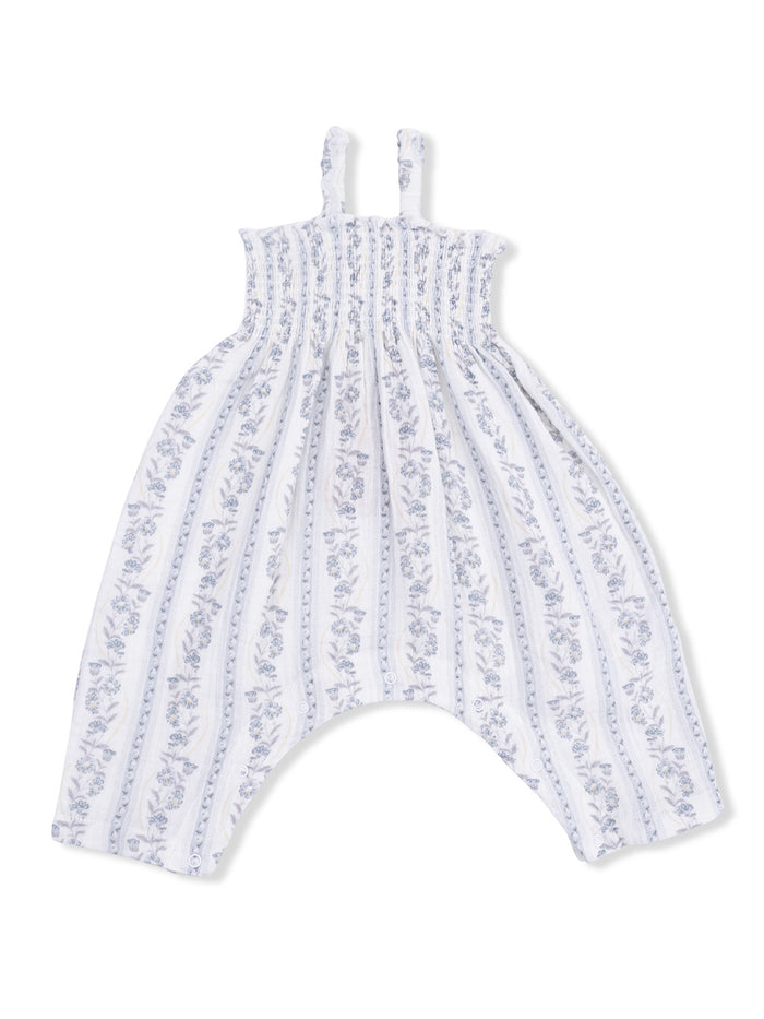 White baby romper with blue floral patterns and ruffled straps, designed for comfort and style.