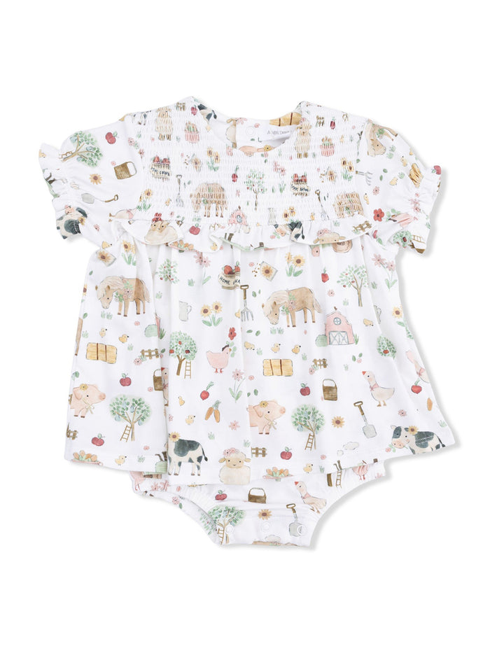 White baby outfit with colorful farm animal patterns and floral designs, featuring ruffled sleeves and a smocked bodice.