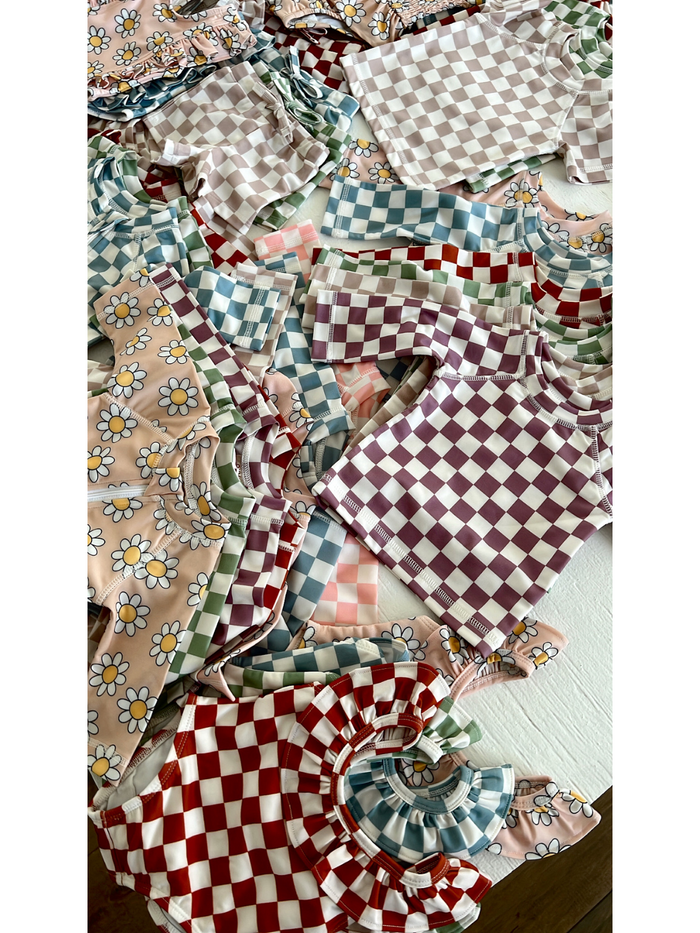 A vibrant assortment of children's clothing featuring floral and checkered patterns in various colors.