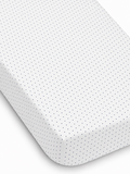 White fitted sheet with navy blue polka dots, showcasing texture and neat edges. Ideal for bedding decor.