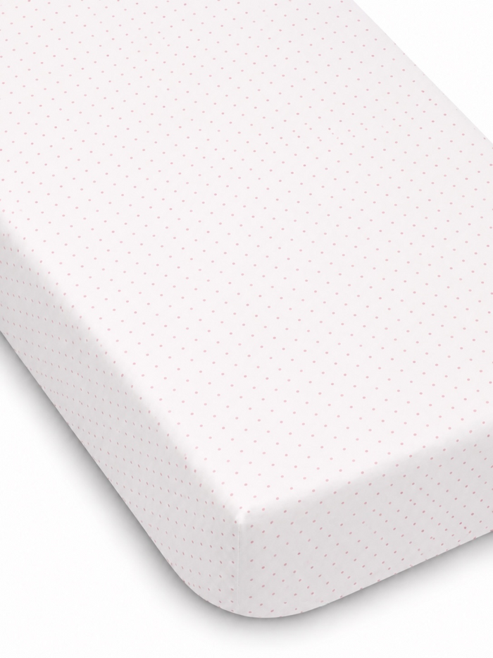 White mattress cover with small pink dots, featured at an angle to show the fitted edge.