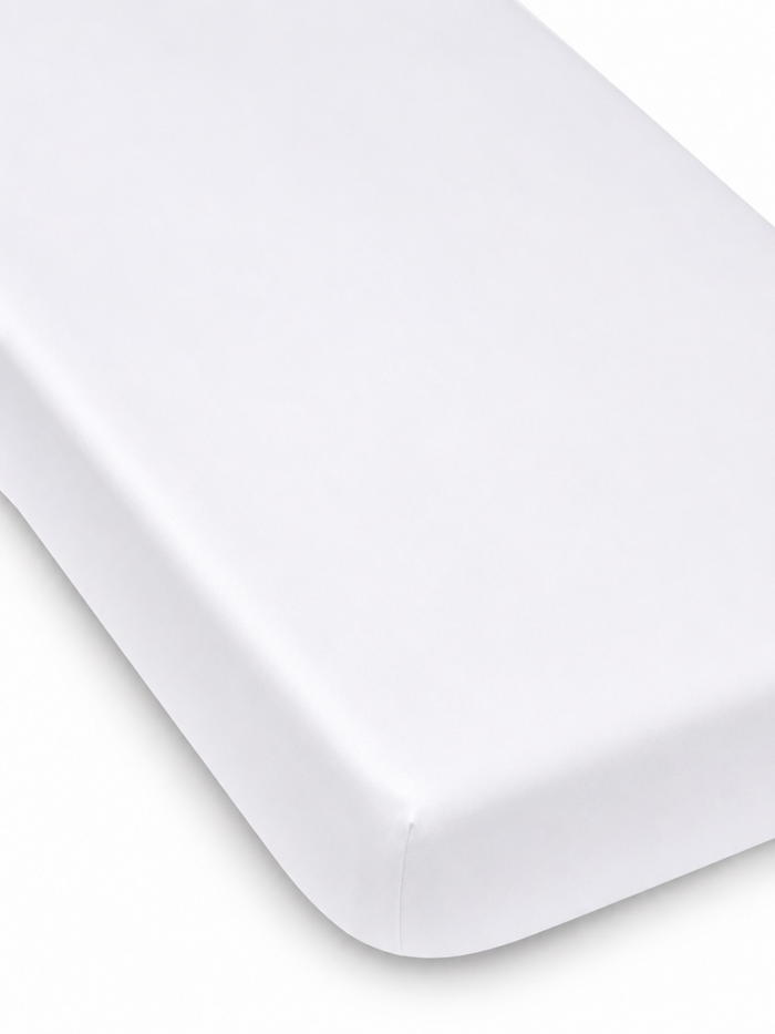 White mattress corner on a light background, featuring a smooth, clean finish. Ideal for a minimalist aesthetic.