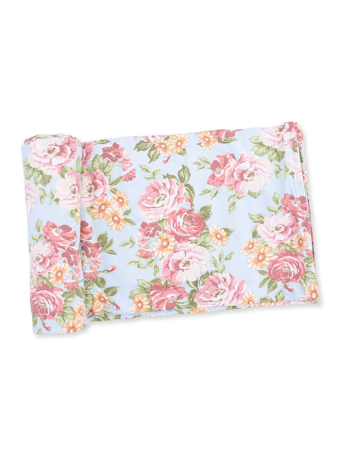 Floral-patterned blanket featuring pink roses and daisies on a light blue background.