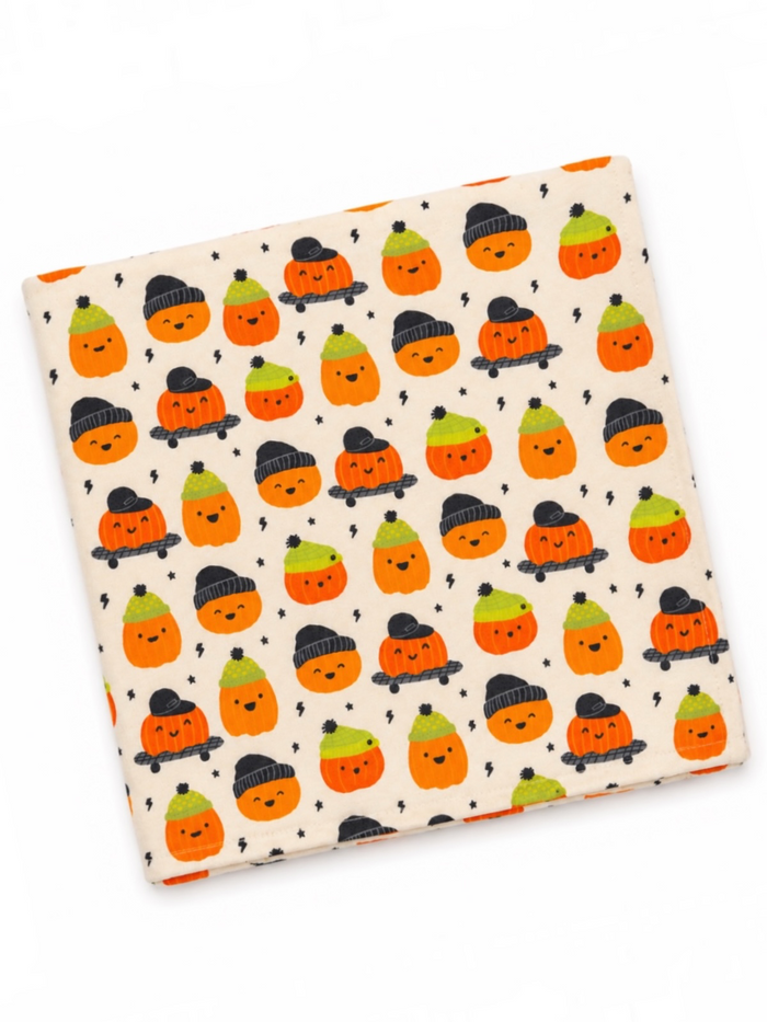 Cute patterned fabric featuring smiling pumpkins wearing hats on a light background. Ideal for Halloween decor.