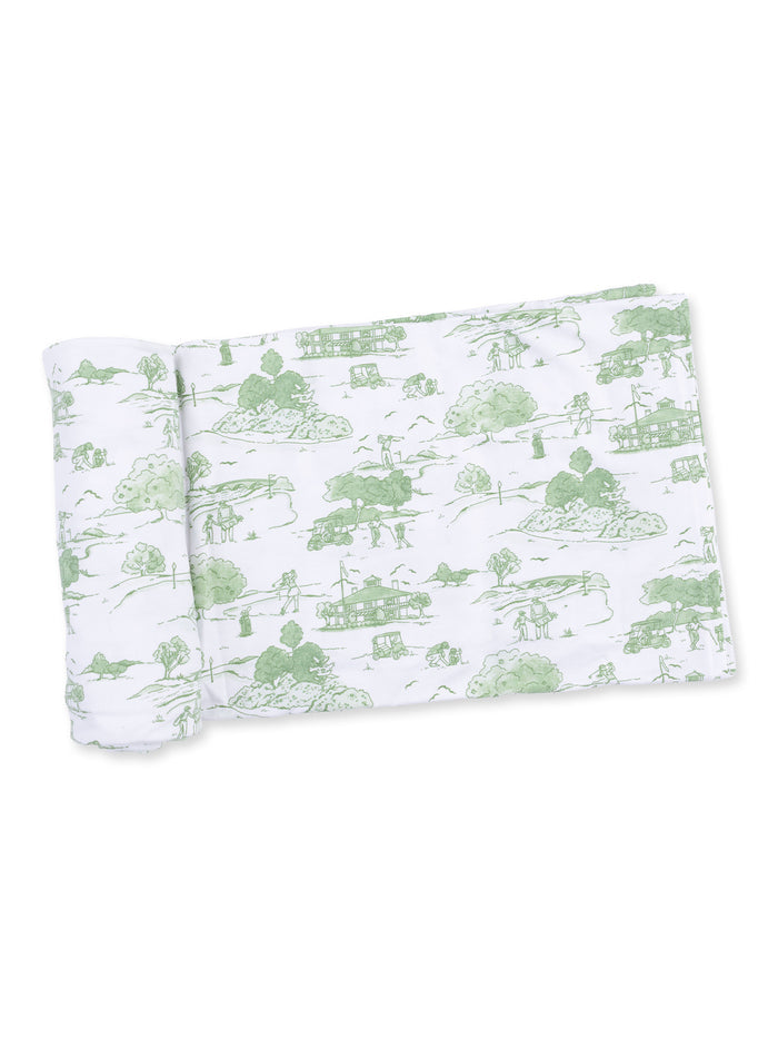 Green and white patterned fabric featuring scenic illustrations of nature and rural life.