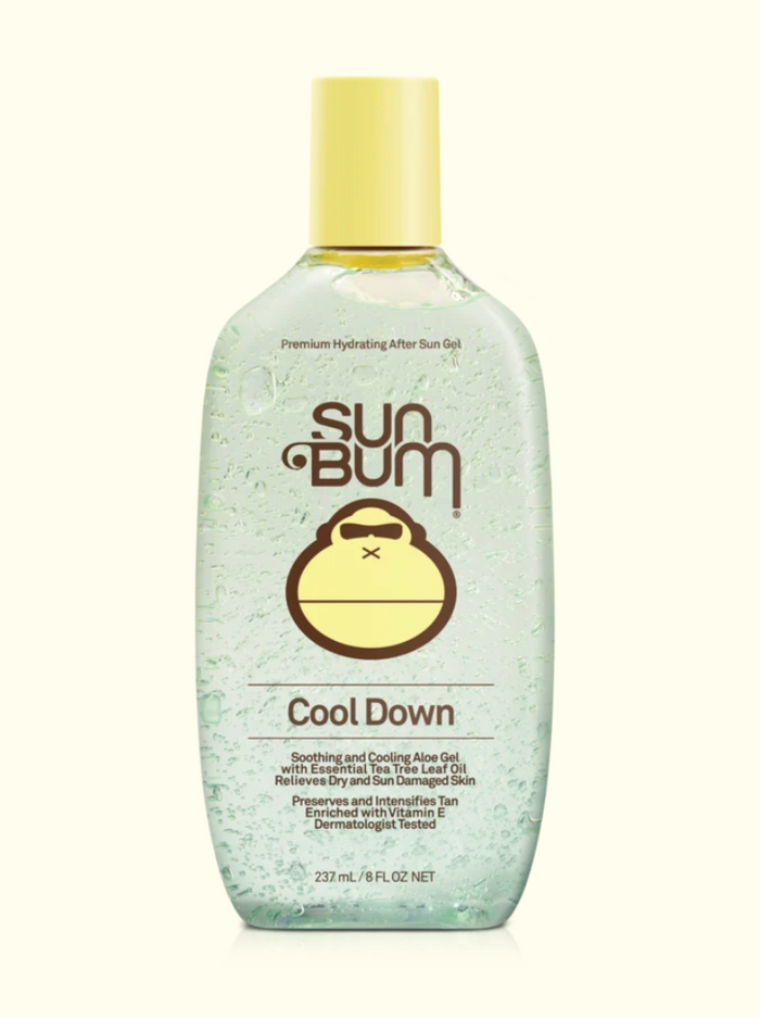 A series of four Sun Bum brand skin care products including sunscreen lotion, after sun cool down lotion, after sun cool down gel, and browning lotion, displayed outdoors.