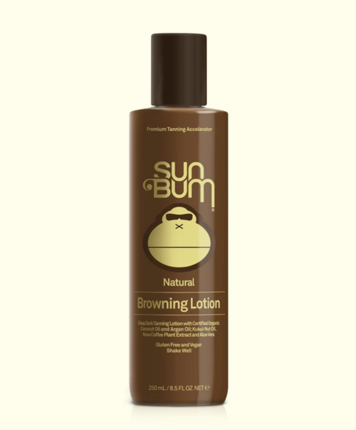 A series of four Sun Bum brand skin care products including sunscreen lotion, after sun cool down lotion, after sun cool down gel, and browning lotion, displayed outdoors.