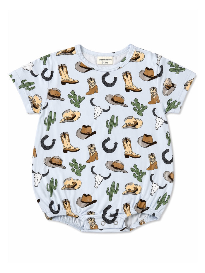 Light blue baby romper with cowboy boots, hats, cacti, and cattle motifs throughout the fabric.