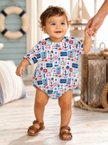 Smiling toddler in a nautical-patterned outfit walking while holding an adult's hand on a beach-inspired interior.