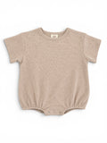 Light beige baby onesie with short sleeves and snap closures at the bottom, featuring a textured fabric.
