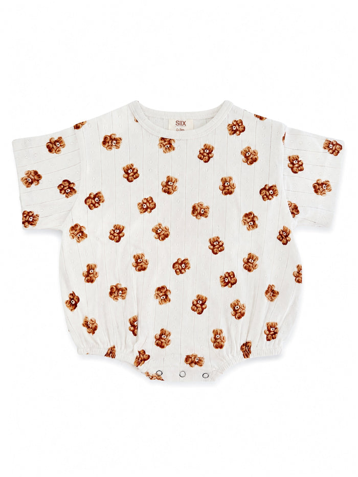 White baby romper with a playful bear print pattern, featuring short sleeves and snap closures.