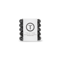 Stack of black hair ties with a white label featuring 'Teleties' branding on a white background.