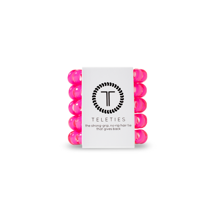 Stack of pink hair ties with a white label featuring 'Teleties' branding on a white background.