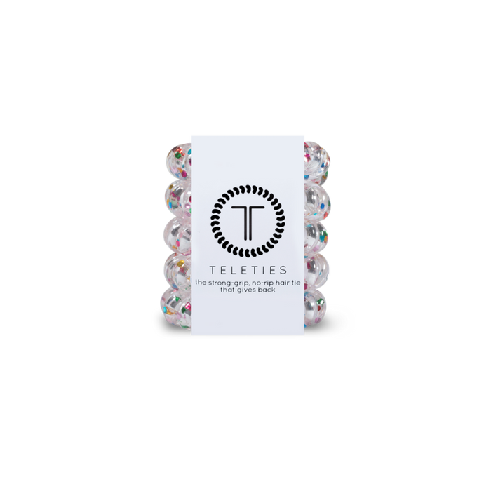 Stack of clear and colored speckeled hair ties with a white label featuring 'Teleties' branding on a white background.