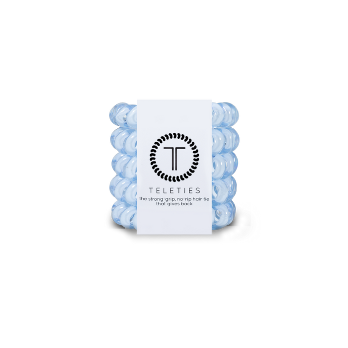 Stack of light blue hair ties with a white label featuring 'Teleties' branding on a white background.