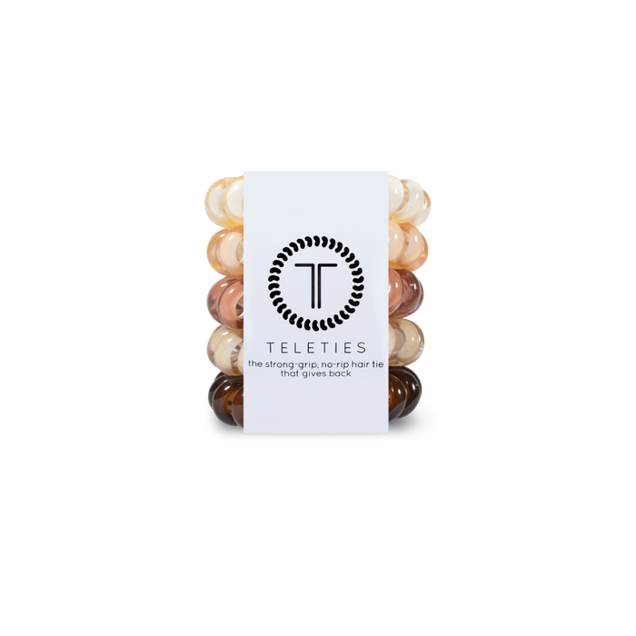 Stack of neutral shades hair ties with a white label featuring 'Teleties' branding on a white background.