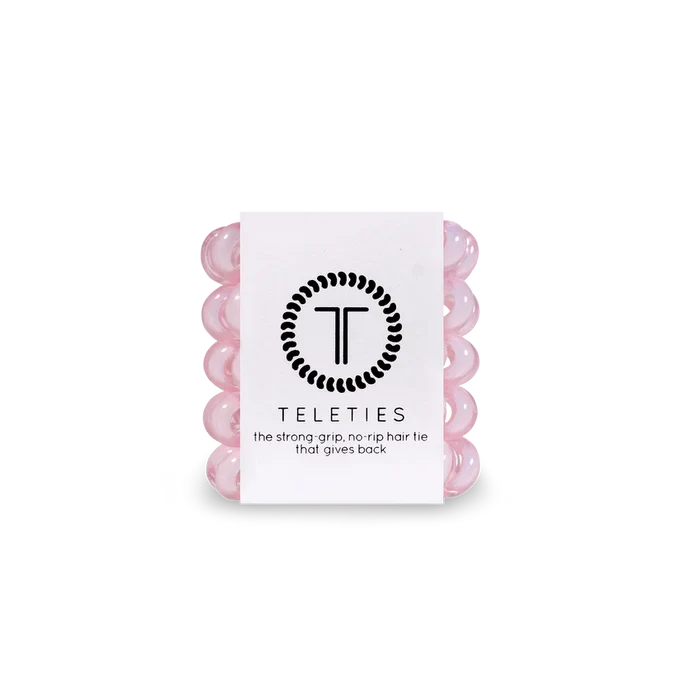 Stack of light pink hair ties with a white label featuring 'Teleties' branding on a white background.