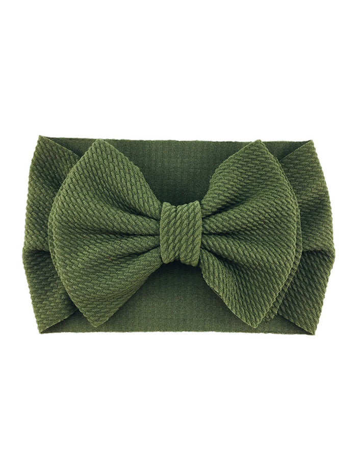 Green textured headband with a large bow, ideal for stylish hair accessories.