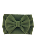 Green textured headband with a large bow, ideal for stylish hair accessories.