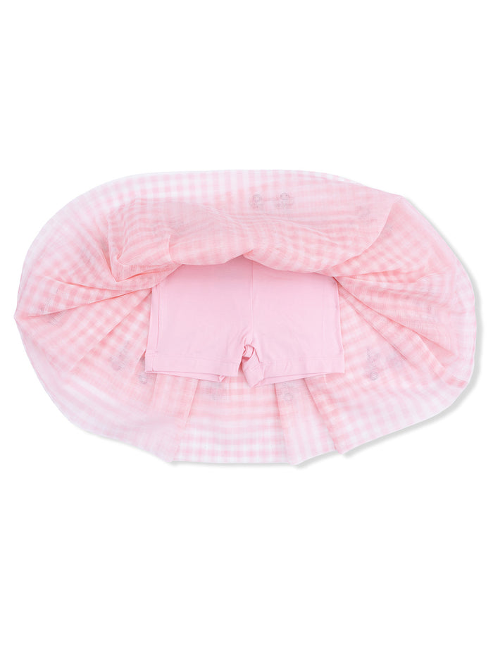 Pink gingham fabric draped over pink shorts, creating a soft, playful outfit layout.
